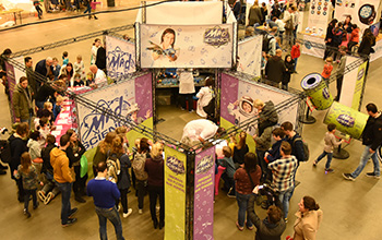 Mad science booth at a trade show with people around looking at the experiments