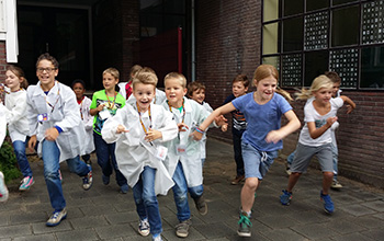 Kids in mad science lab coats running out of school