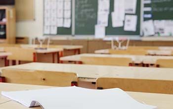 Elementary school desk with open notebook on it.